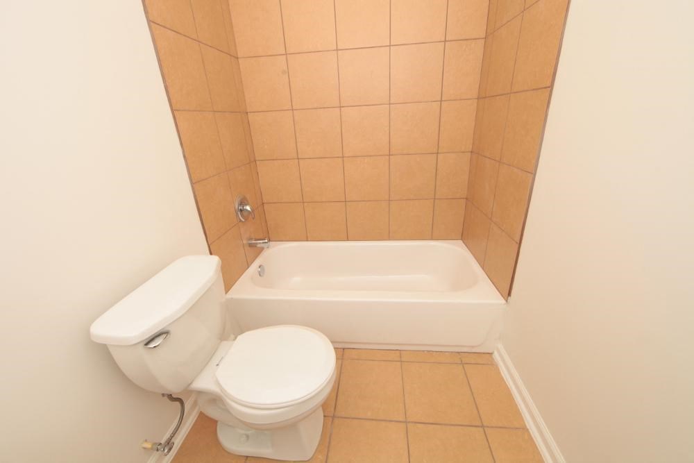 a bathroom with a toilet and a bath tub