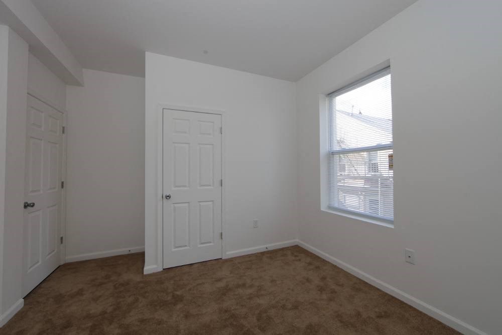 a bedroom with a white door and a window