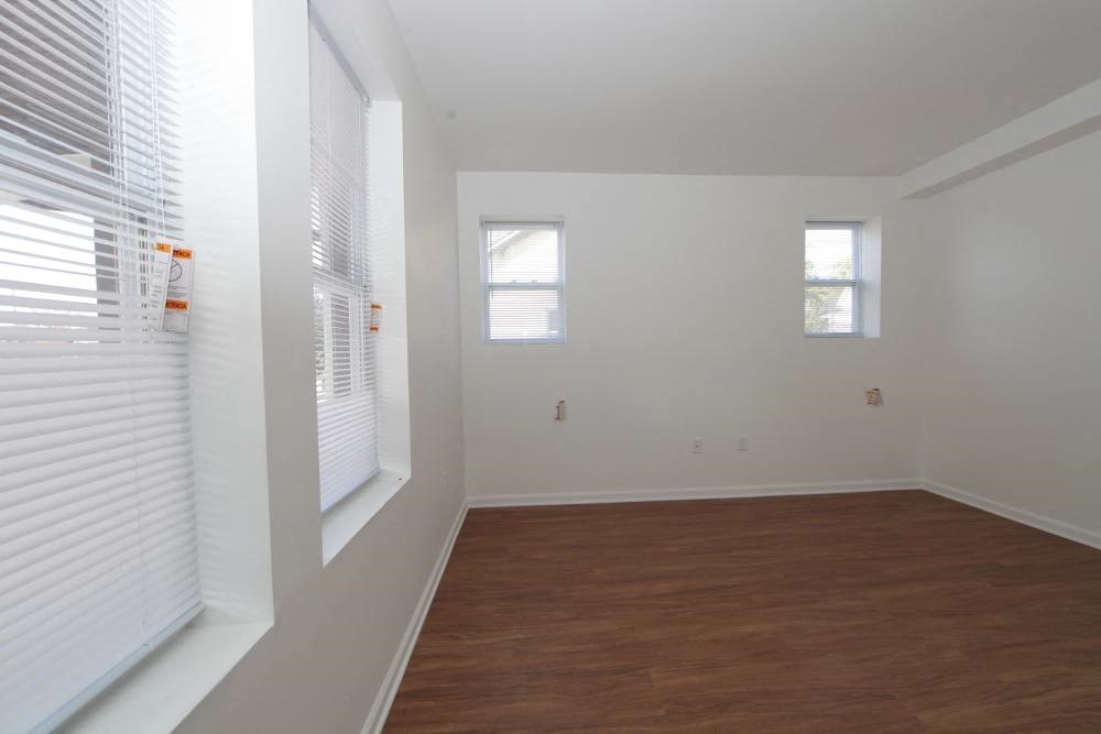 a living room with a wood floor and a large window