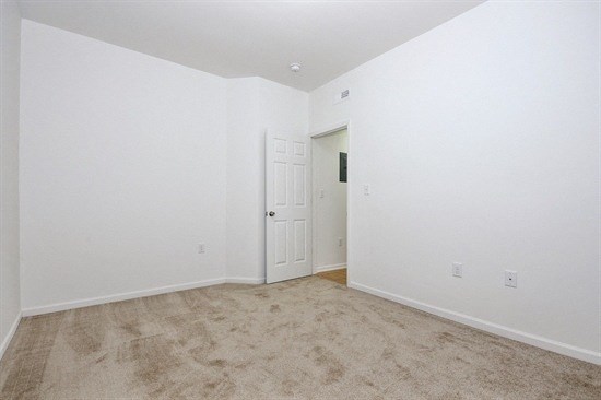 an empty living room with white walls and a white door