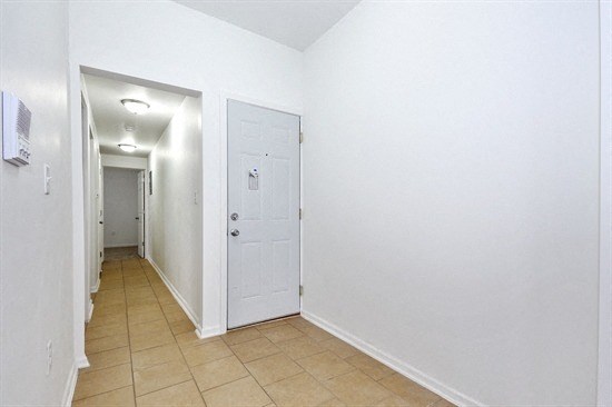 an empty hallway with white walls and a white door