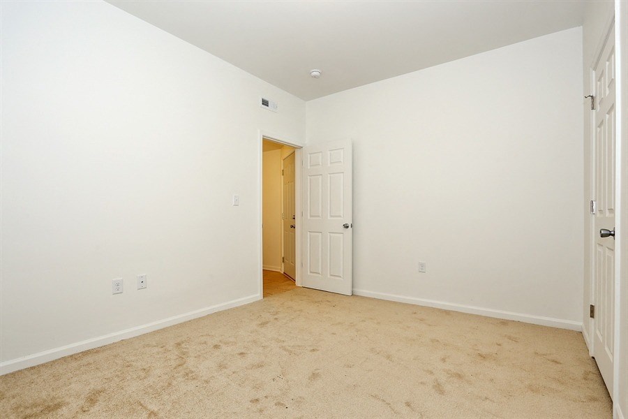 an empty bedroom with a door open to a hallway