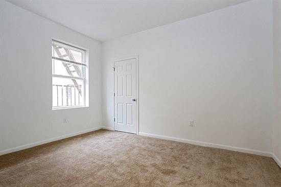 an empty room with white walls and a window and a door