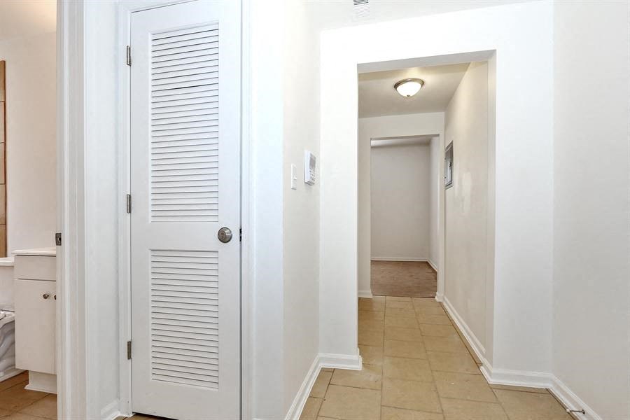 a hallway with a door to a bathroom and a closet