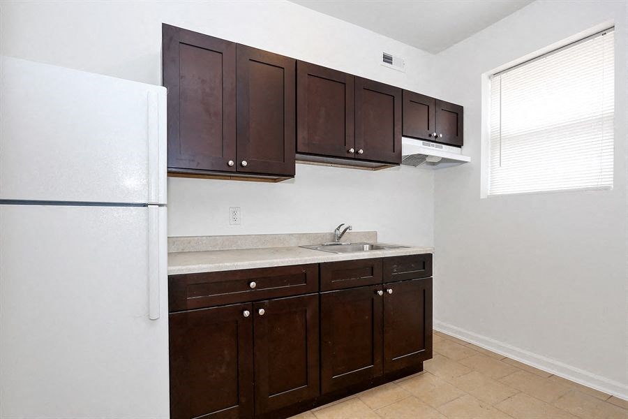 a kitchen with brown cabinets and a refrigerator