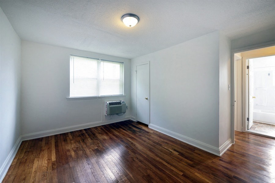 an empty living room with a hard wood floor and a window