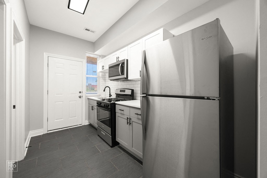 a kitchen with stainless steel appliances and a refrigerator