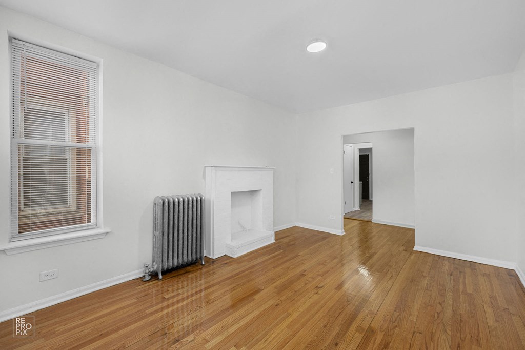 a living room with a wood floor and a fireplace