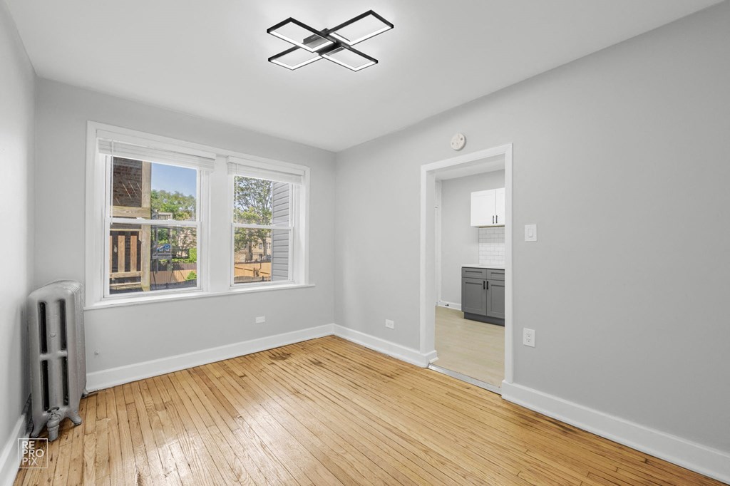 a bedroom with hardwood floors and grey walls