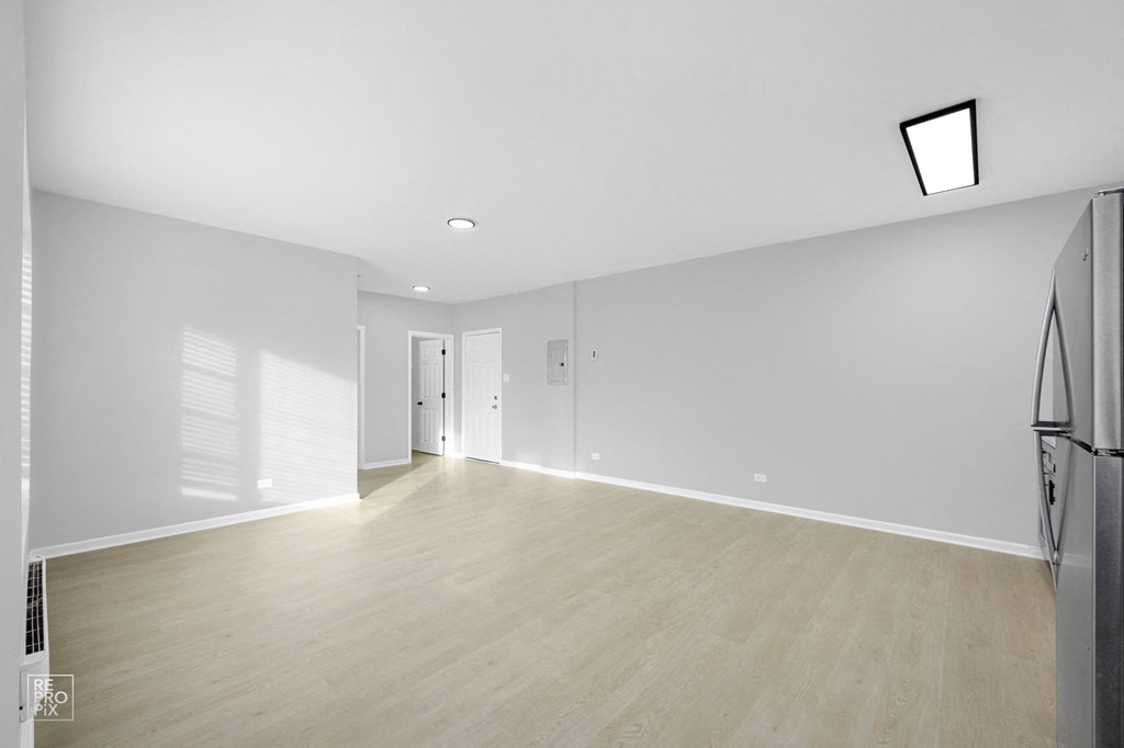 a bedroom with hardwood floors and grey walls