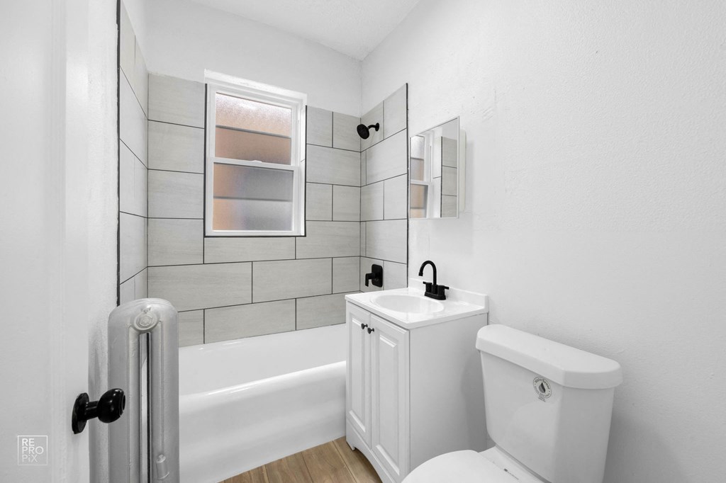 a bathroom with a toilet and a sink and a bath tub