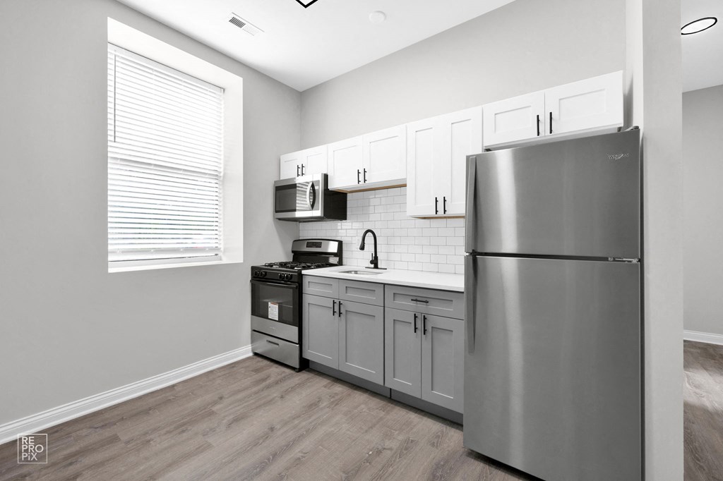 a kitchen with white cabinets and stainless steel appliances