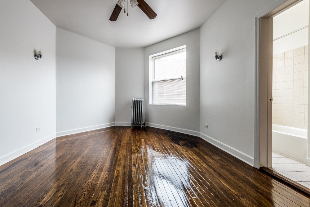 the living room of an empty house with wood floors and a ceiling fan