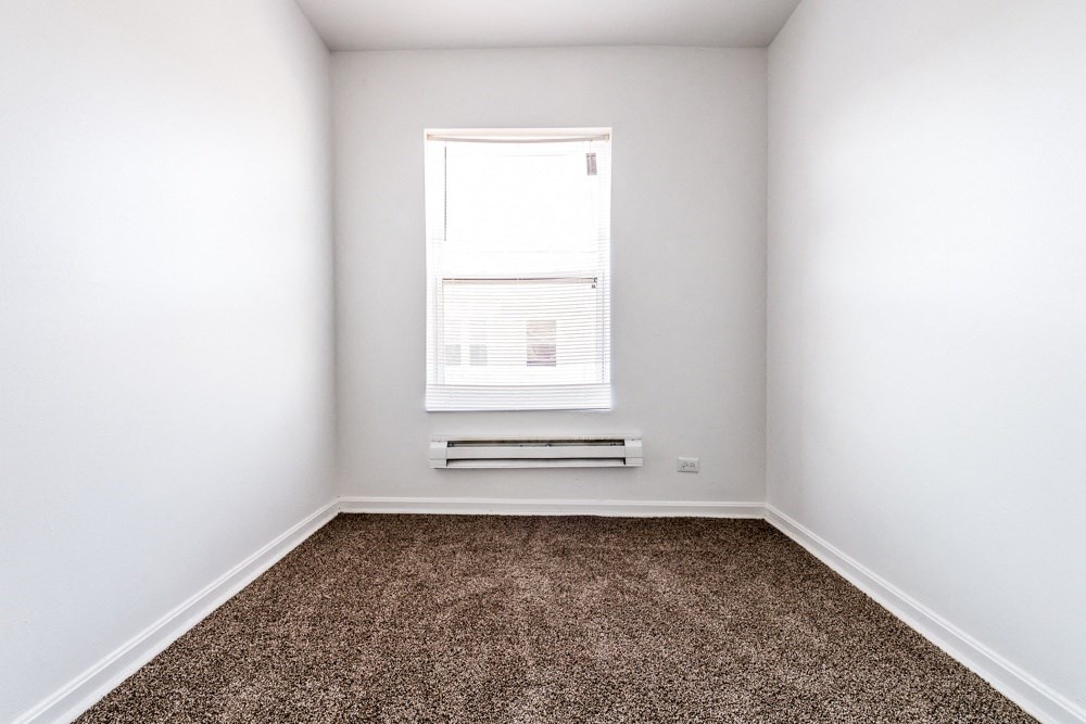 an empty room with carpet and a window