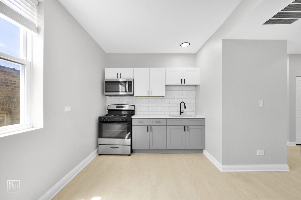 a kitchen with gray cabinets and white appliances