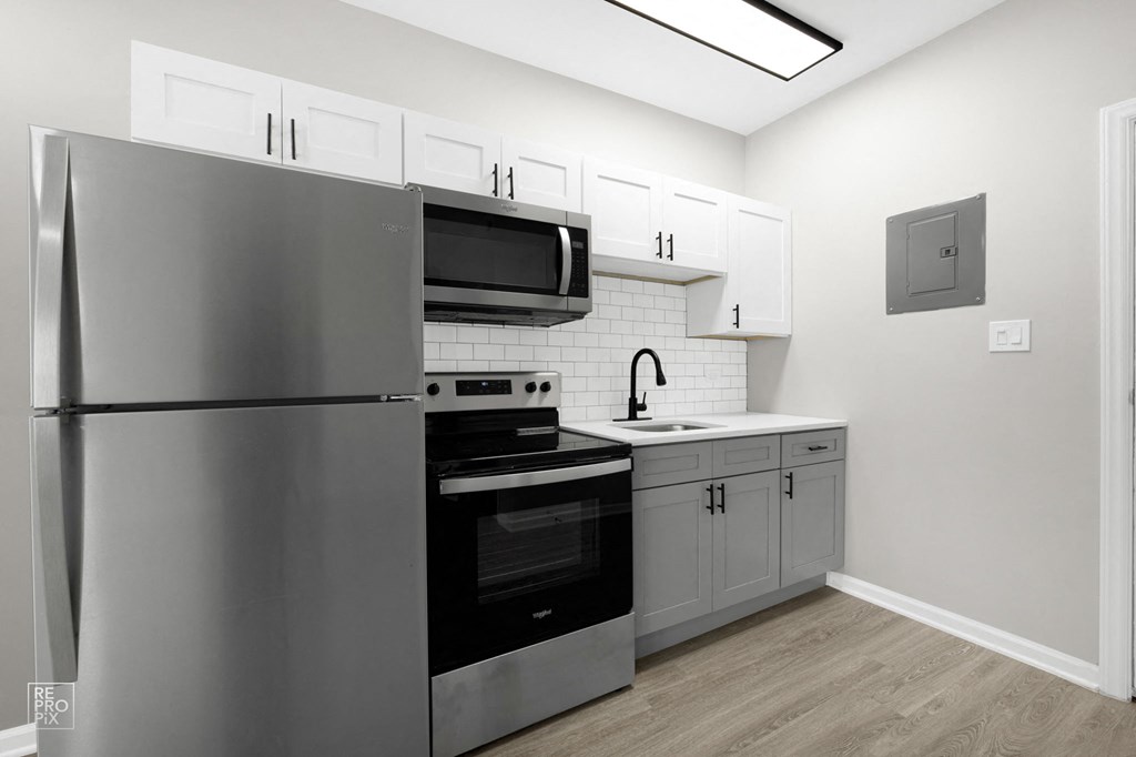 a kitchen with white cabinetry and black appliances