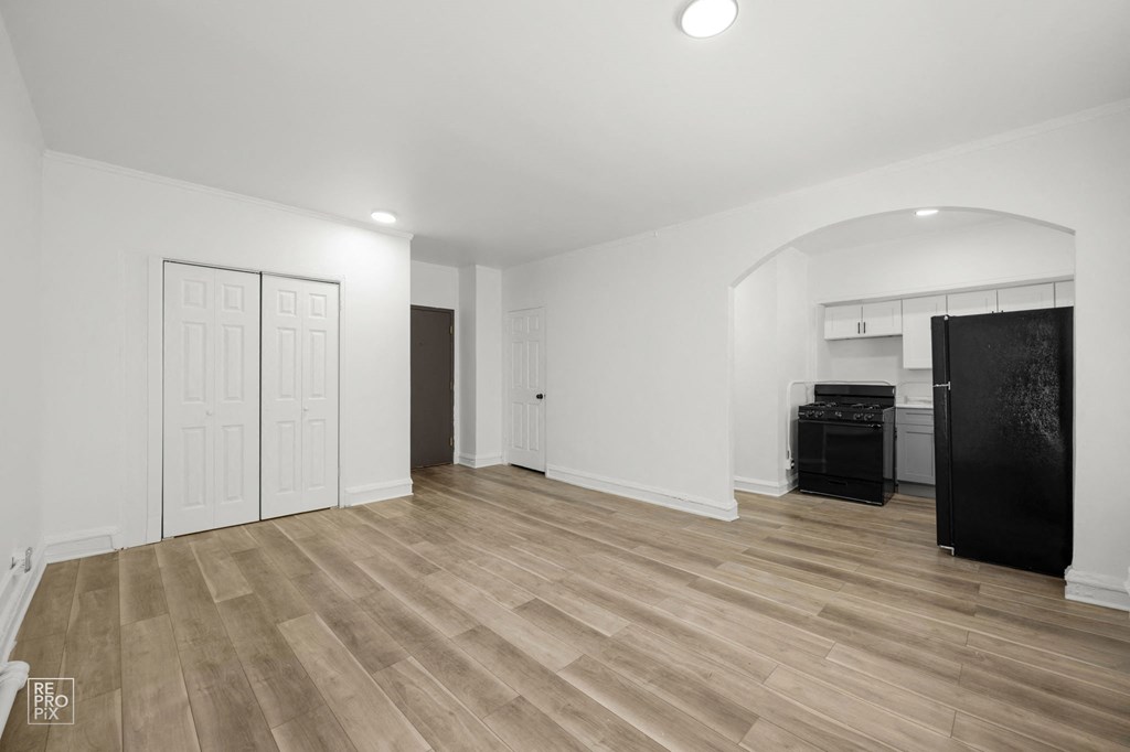 an empty living room with white walls and wood floors