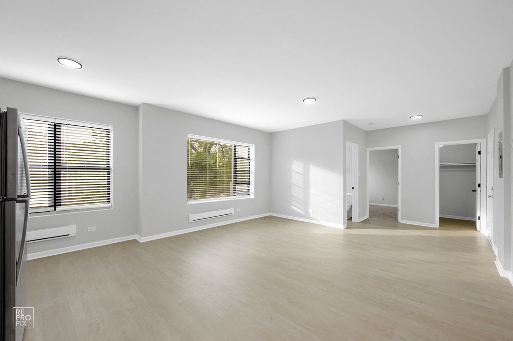 an empty living room with white walls and hardwood floors