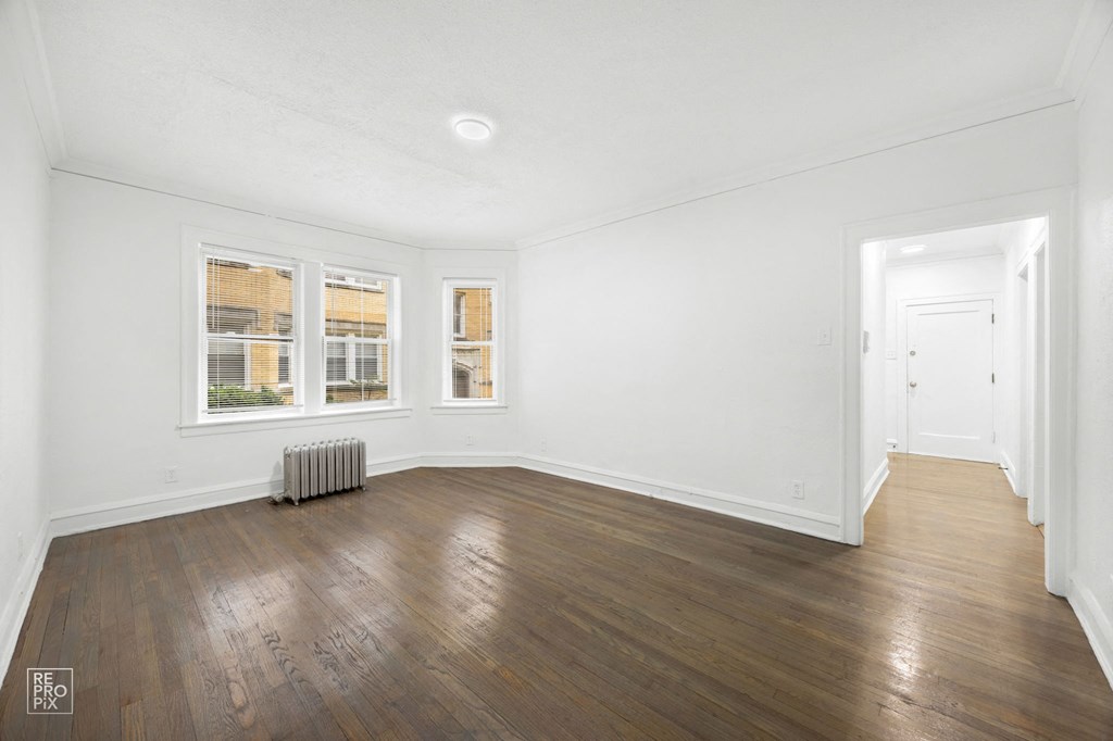 a living room with hardwood floors and white walls
