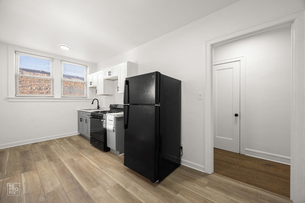 a kitchen with a refrigerator and a stove and a window