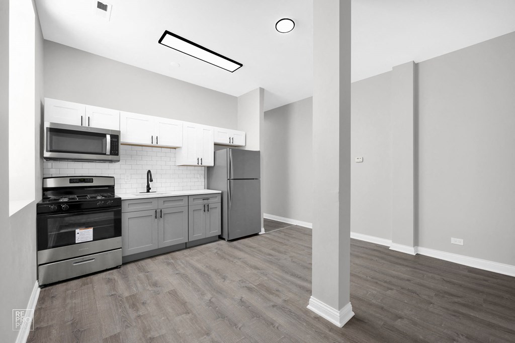 a kitchen with white cabinets and stainless steel appliances
