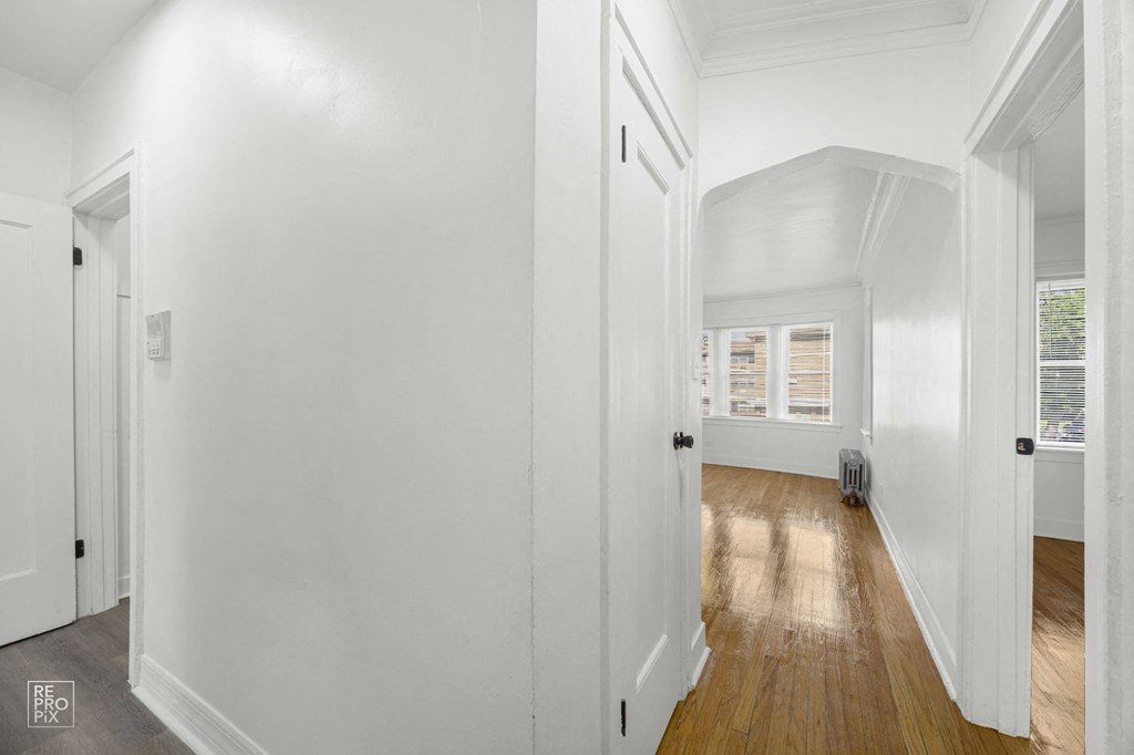 a living room with white walls and wood floors