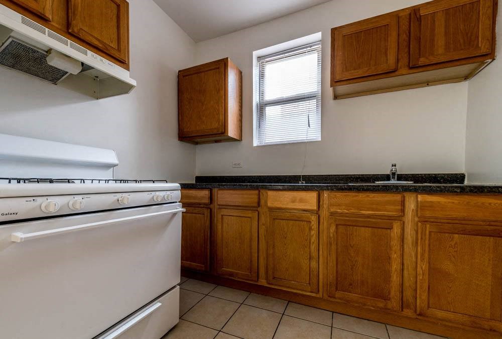 a kitchen with a stove top oven and a sink