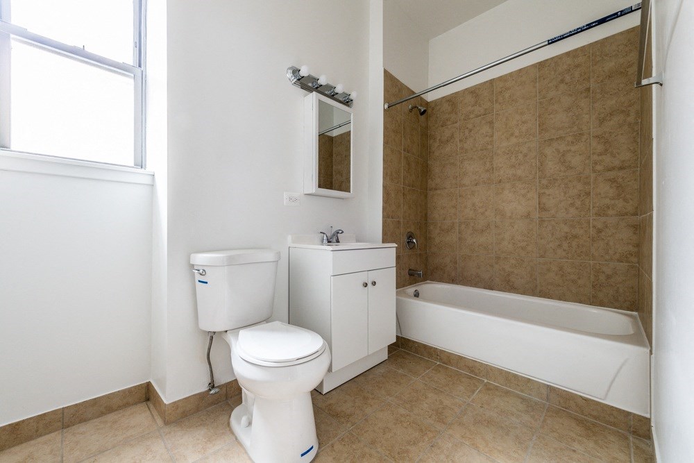 a bathroom with a toilet and a tub and a sink