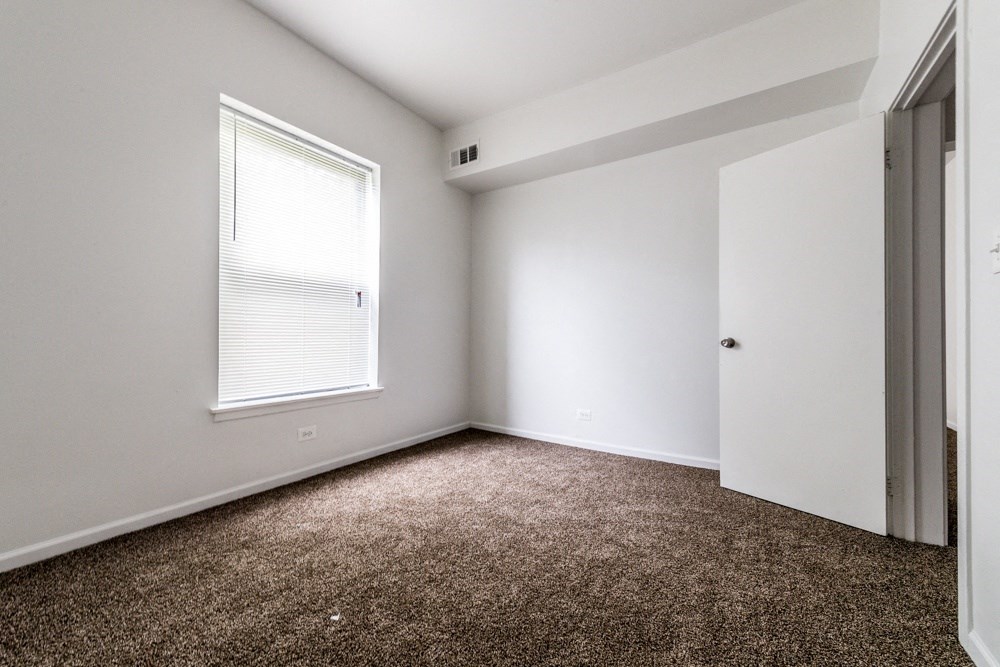 an empty room with carpet and a window