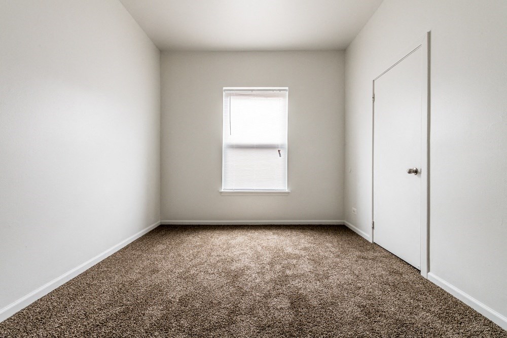 an empty room with a door and a window