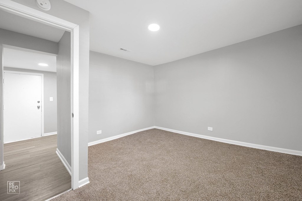 a bedroom with gray walls and a carpet