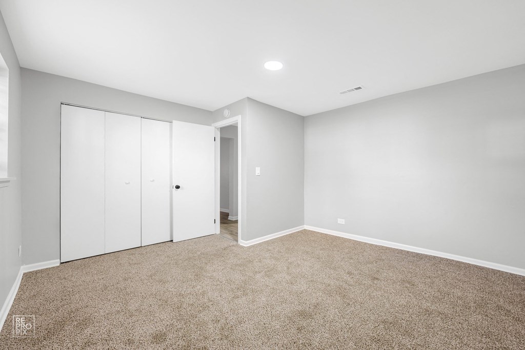a bedroom with a carpeted floor and white walls