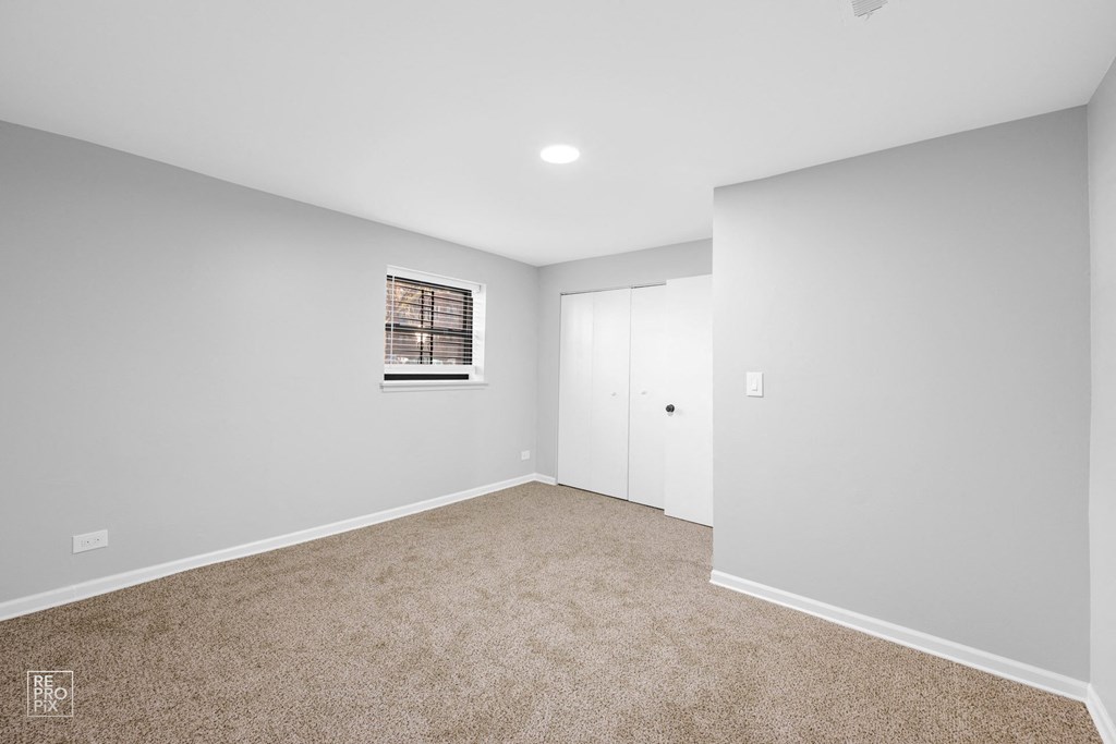 a bedroom with gray walls and carpet