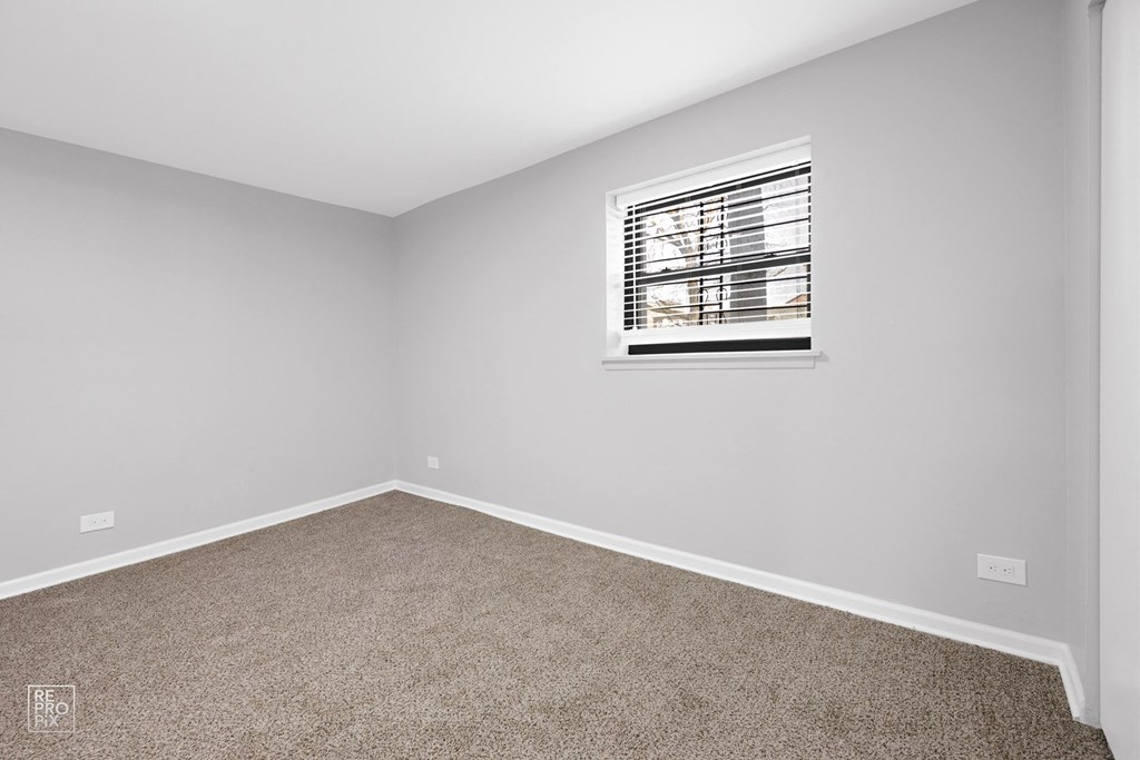 a bedroom with gray walls and a window