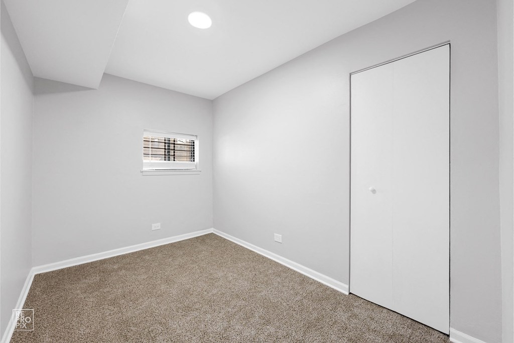 a bedroom with grey walls and carpet