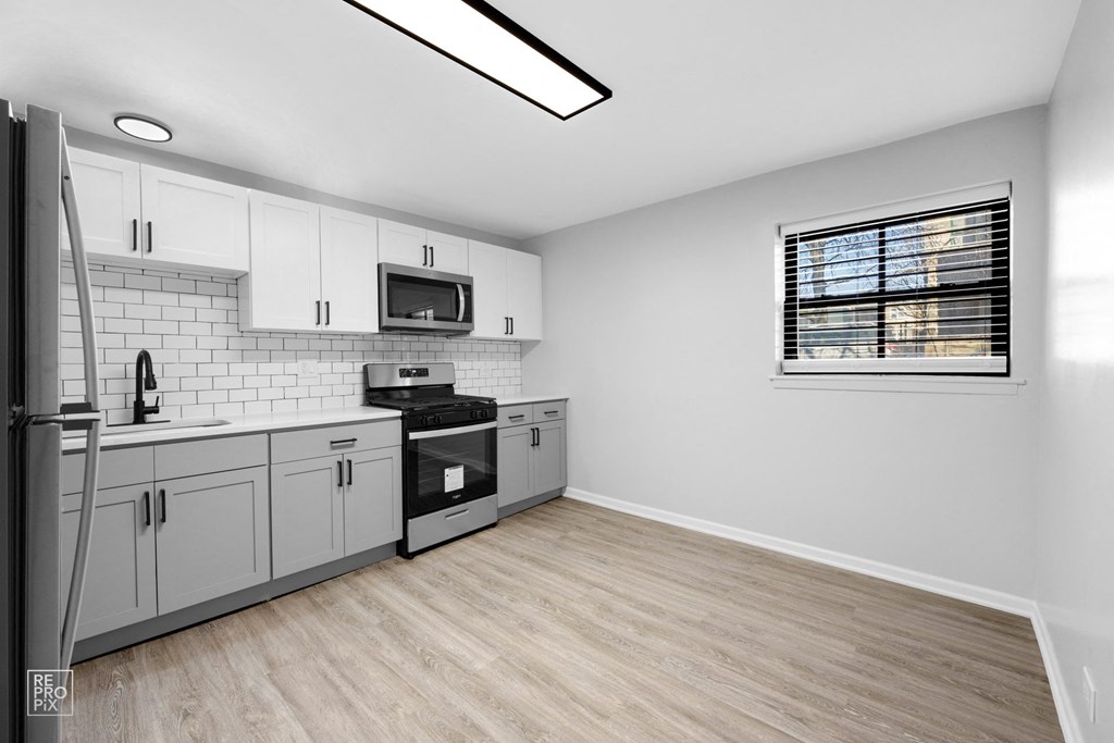 a kitchen with white cabinets and stainless steel appliances
