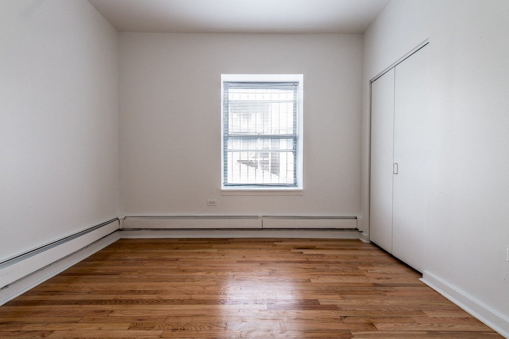 an empty room with wooden floors and a window
