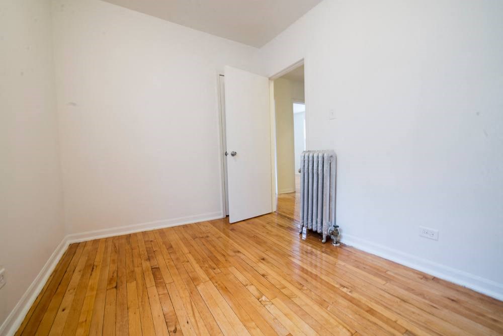 a room with a radiator and a wooden floor