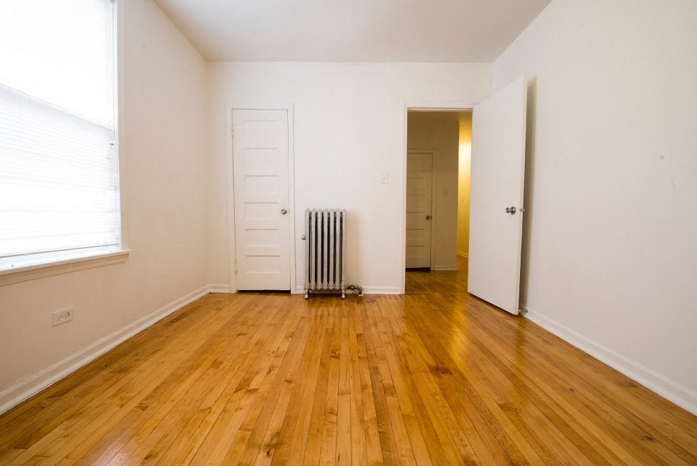 a living room with a wood floor and a radiator
