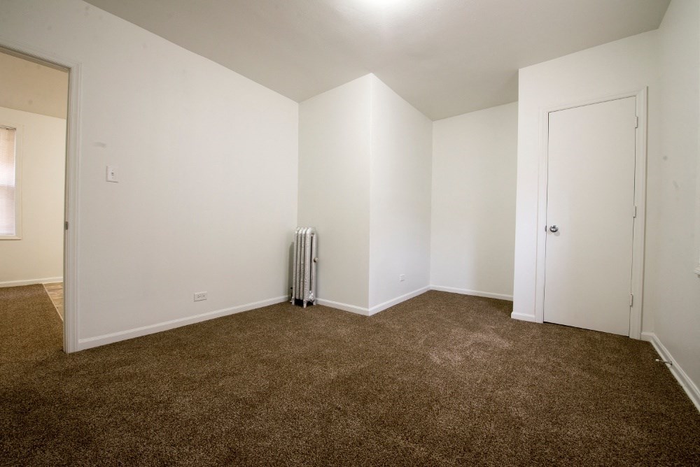an empty living room with carpet and white walls