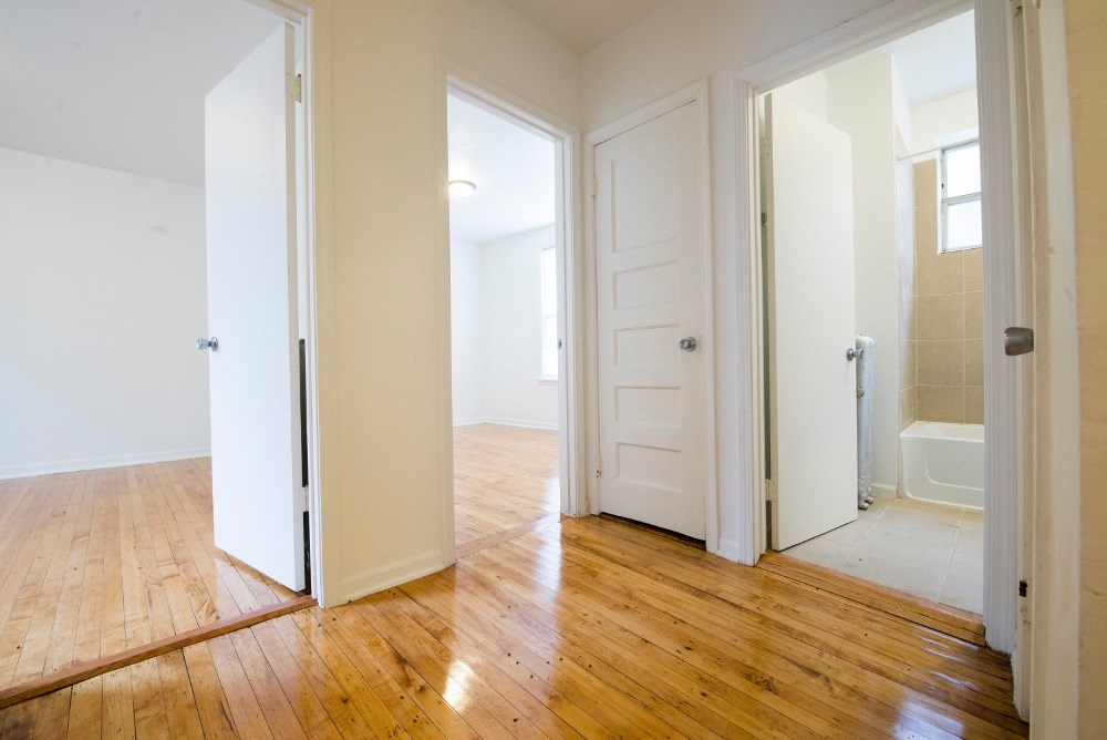 an empty living room with a door open to a bathroom