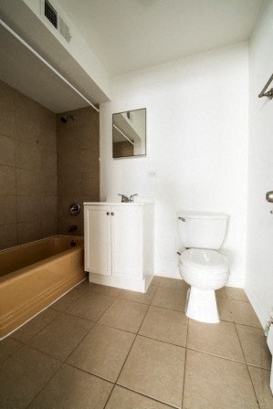 a bathroom with a toilet and a tub and a sink