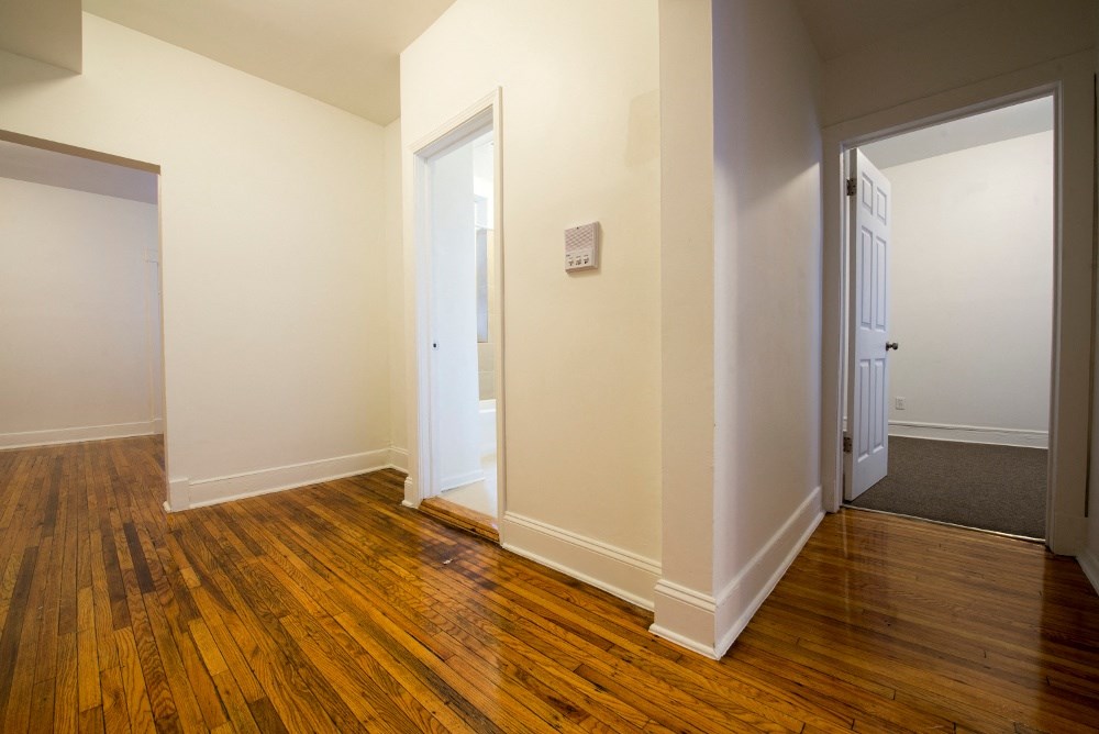 a living room with wood floors and white walls