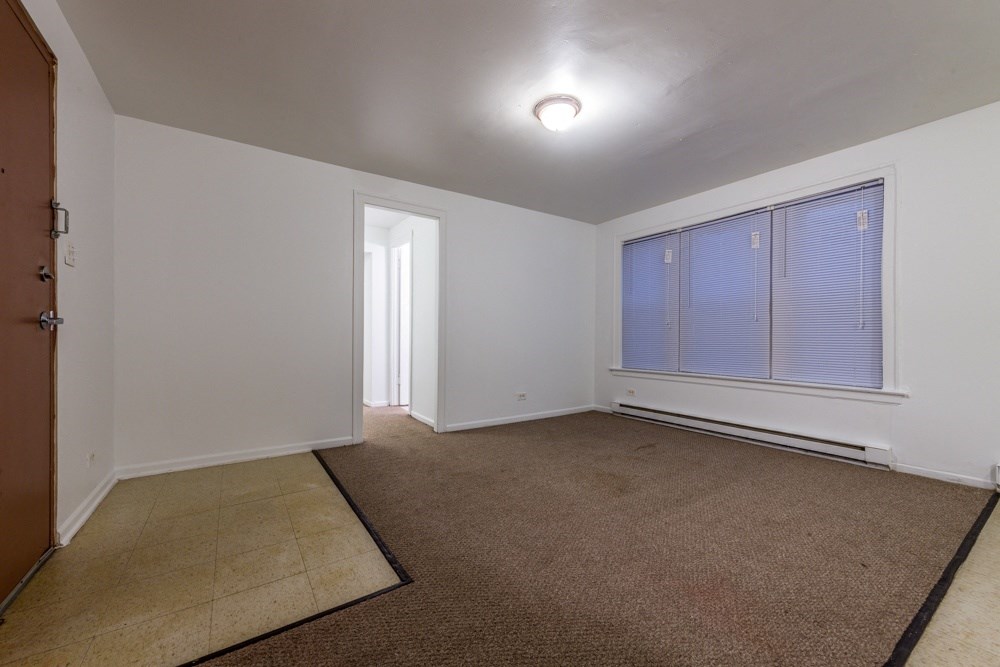 an empty living room with a large window and a door