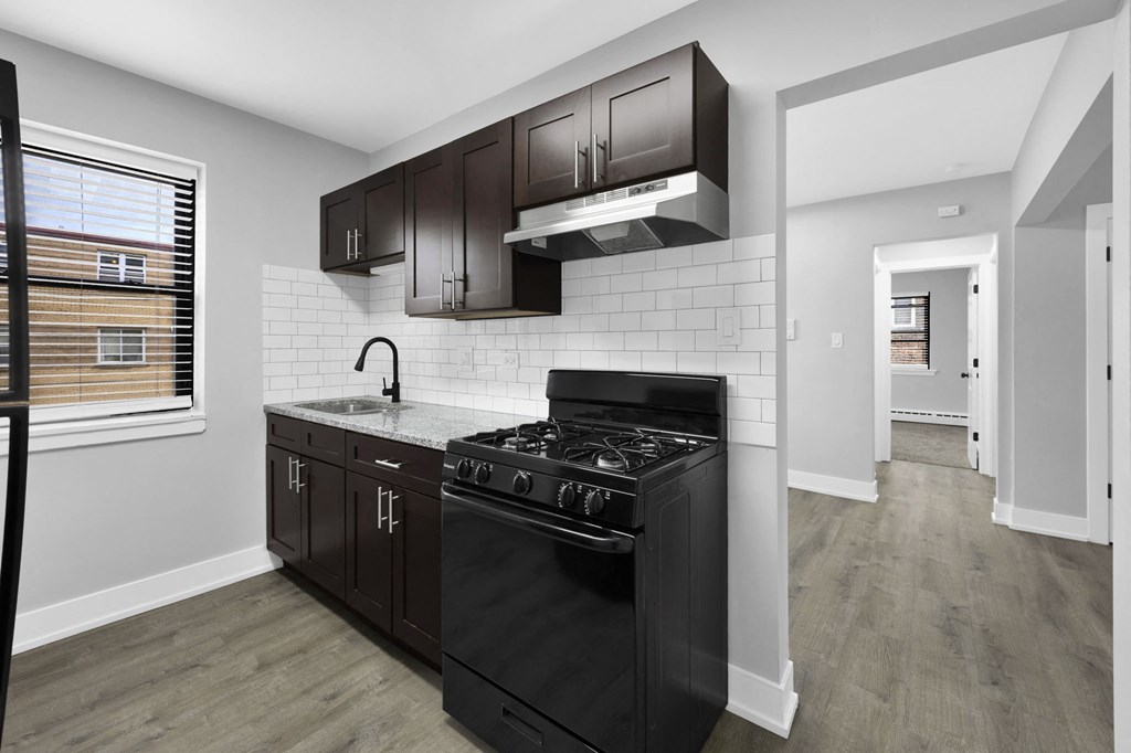 a kitchen with black cabinets and a black stove top oven
