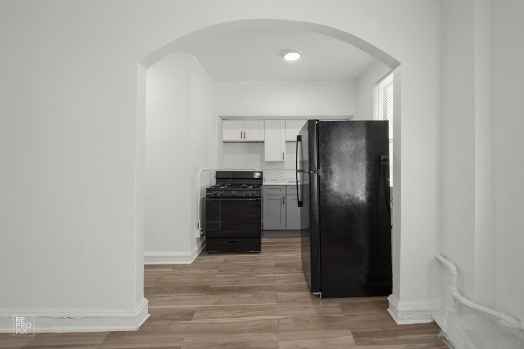 a kitchen with a black refrigerator and a black stove and