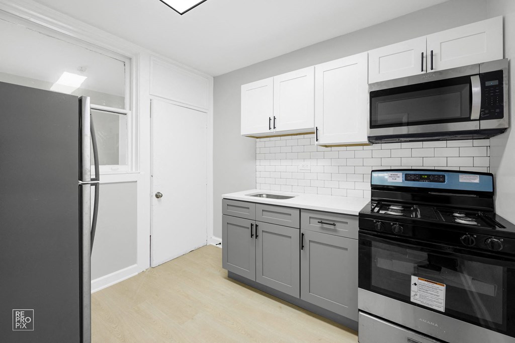 a kitchen with white cabinets and stainless steel appliances