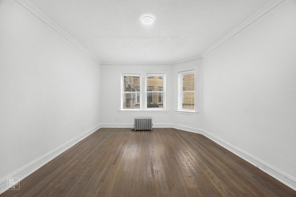 an empty living room with white walls and wood floors