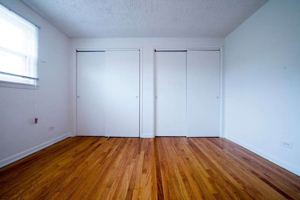 an empty room with white walls and wooden floors