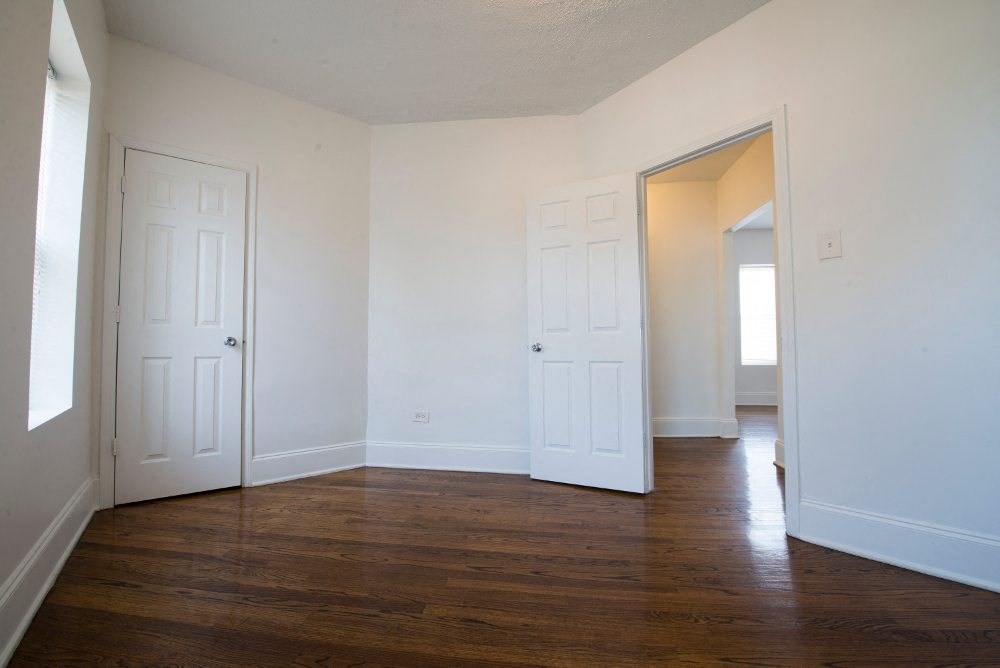 an empty living room with white walls and wood floors